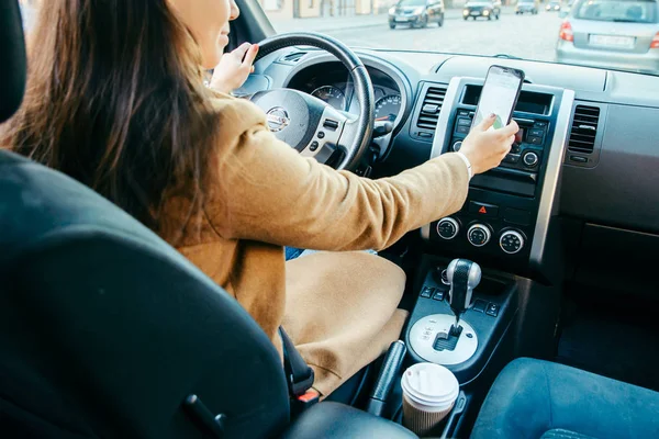 Young woman driving car and using phone as navigation — Stock Photo, Image
