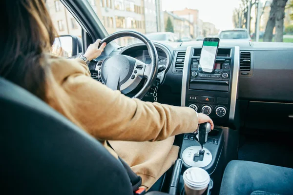 Mladá žena řídí auto a telefon jako navigaci — Stock fotografie