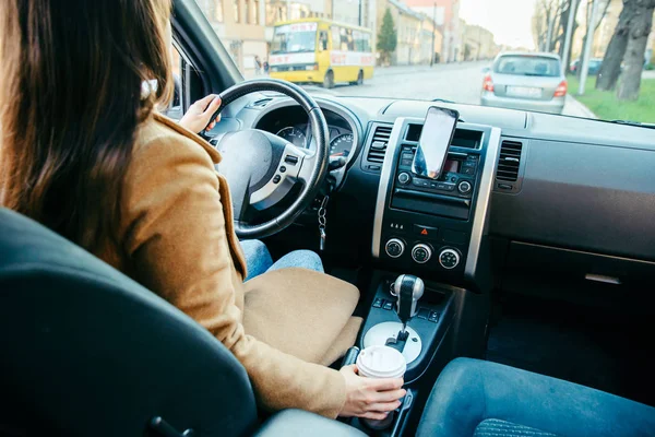 Woman driving car and drinking coffee. phone navigation — Stock Photo, Image