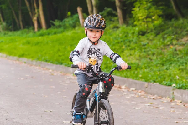 LVIV, UCRANIA - 18 de agosto de 2018: niño pequeño en bicicleta con casco — Foto de Stock