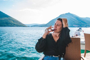 gülümseyen genç kadın, güzel dağ manzaralı sahil kırmızı şarap içme