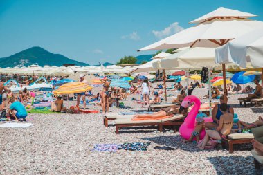Sveti Stefan, Karadağ: 18 Temmuz 2018: yaz saati. insanlar kayalık Plajı. Güneş şemsiye ve şezlong