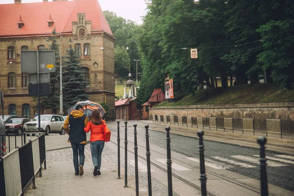 Пара ходьба по міській вулиці з парасолькою — стокове фото