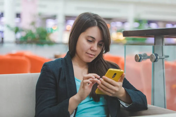 Mujer con teléfono sentado en la cafetería —  Fotos de Stock