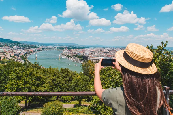 Молодая женщина фотографируется со смартфоном старого европейского города — стоковое фото