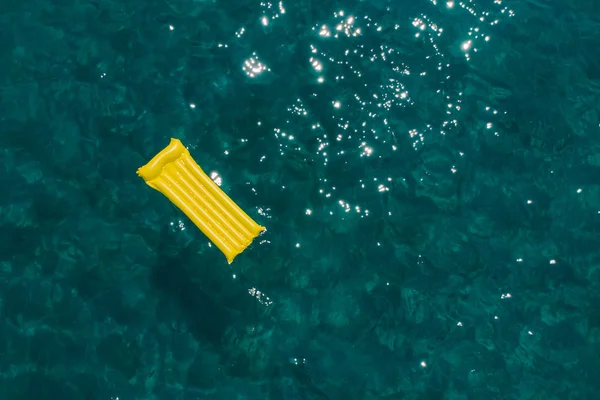 Concept de vacances d'été. matelas gonflable jaune en bleu azur eau de mer . — Photo