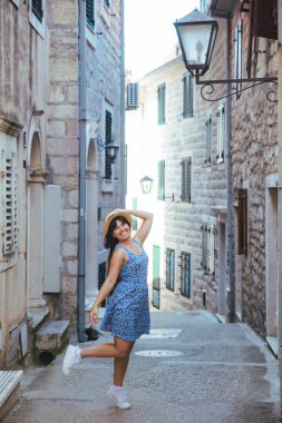 Herceg Novi küçük sokaklarında yürüyüş mavi elbiseli genç güzel kadın