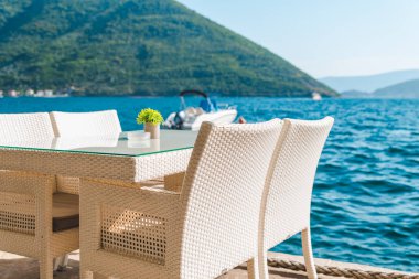 güzel bir deniz ve dağ manzarası ile sahilde Cafe tablo