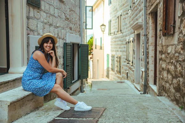 Ung leende sitter på trappan av gammal europeisk stad med trånga gator — Stockfoto