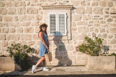 kadın taş duvar ile kapamak ahşap pencere önünde poz
