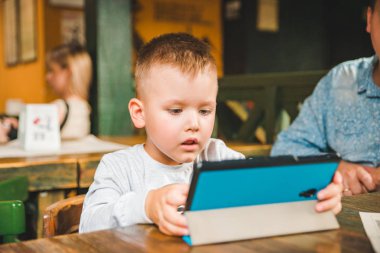 Tablet ile oturan küçük çocuk