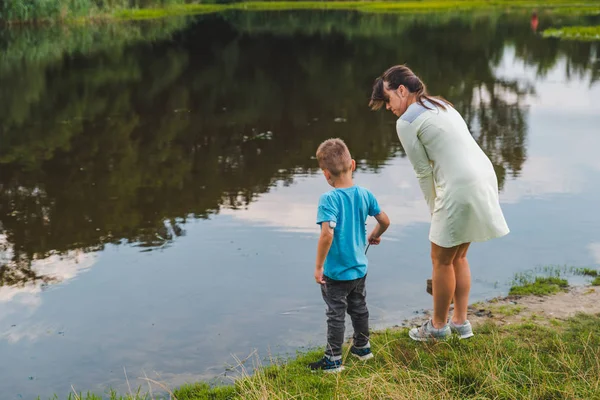 Μητέρα με το γιο του παίζει κοντά στο νερό της λίμνης — Φωτογραφία Αρχείου