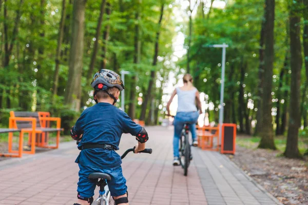 Mujer enseñar pequeño niño en bicicleta — Foto de Stock