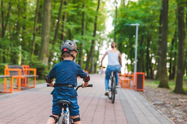 Mujer enseñar pequeño niño en bicicleta — Foto de Stock