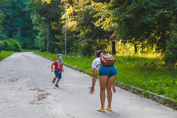 Copil mic care rulează de parc oraș în mâini de femeie — Fotografie, imagine de stoc