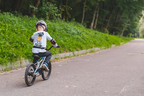 Львов, Украина - 18 августа 2018 года: мальчик катается на велосипеде в шлеме — стоковое фото