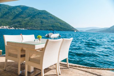 güzel bir deniz ve dağ manzarası ile sahilde Cafe tablo