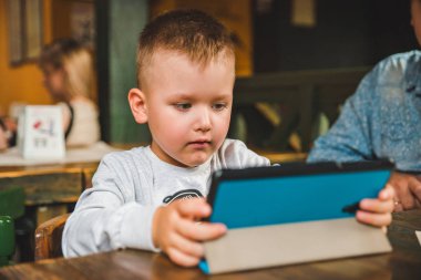 Tablet ile oturan küçük çocuk