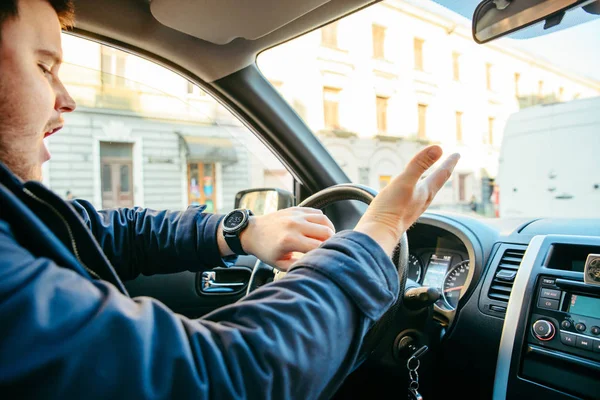 Muž řídil auto v městském provozu. Pospěš. pozdě na schůzky — Stock fotografie