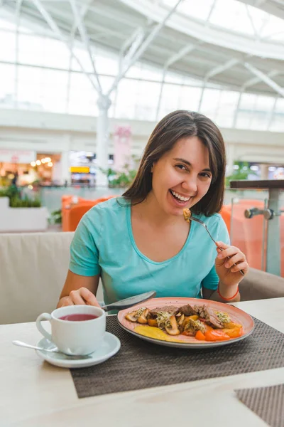 Mujer comiendo en el café del centro comercial de la ciudad — Foto de Stock