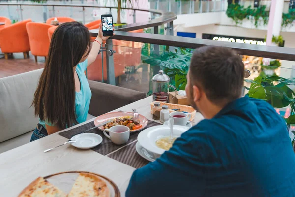 Couple eating in cafe. woman taking selfie on her phone — Stock Photo, Image