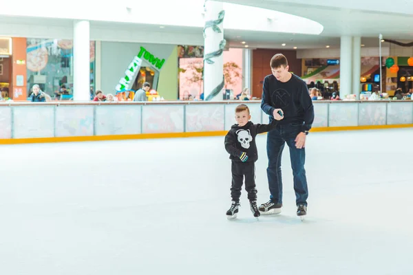 LVIV, यूक्रेन 3 फरवरी 2019: पिता बेटे को स्की रिंक पर स्केट कैसे करना सिखाता है — स्टॉक फ़ोटो, इमेज