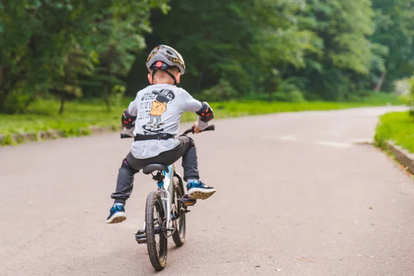 LVIV, UCRANIA - 18 de agosto de 2018: niño pequeño en bicicleta con casco — Foto de Stock