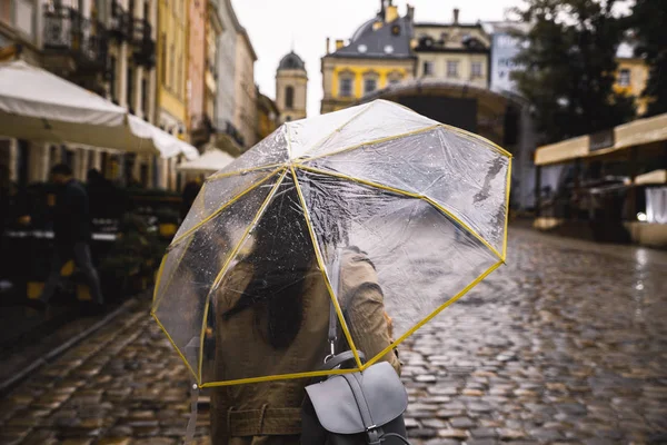 Mujer caminando con paraguas transparente bajo la lluvia — Foto de Stock