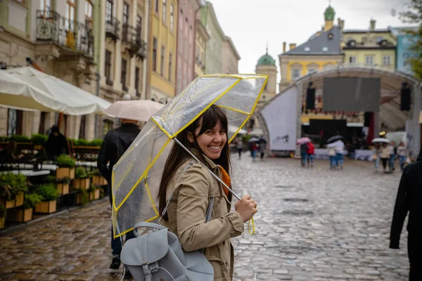 Woman walking with transparent umbrella under rain — Stock Photo, Image