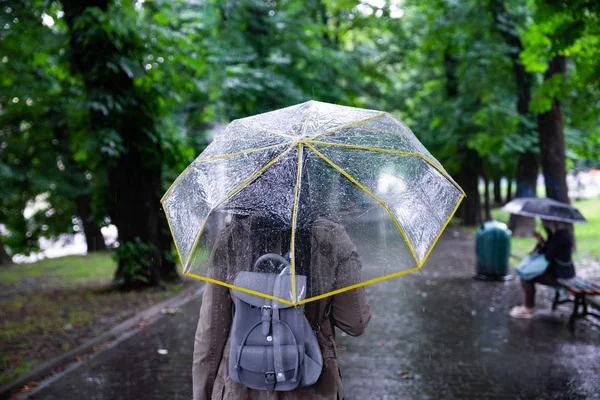 Tempo piovoso. donna che cammina con ombrello dal parco cittadino — Foto Stock