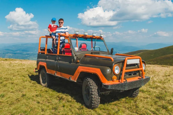 Padre con figlio sulla macchina suv in cima alla montagna — Foto Stock