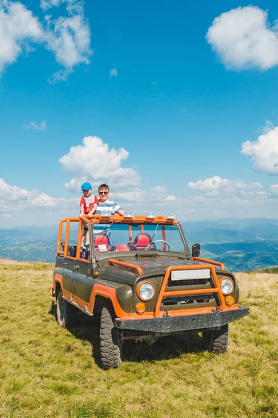 Padre con figlio sulla macchina suv in cima alla montagna — Foto Stock