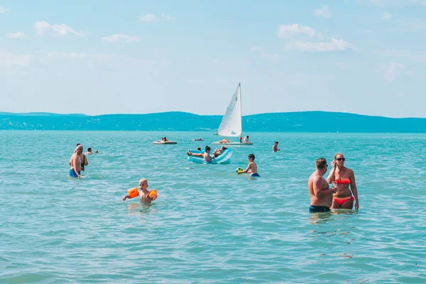 BALATÓN, HUNGRÍA - 14 de julio de 2018: personas nadando en el lago azul azul — Foto de Stock