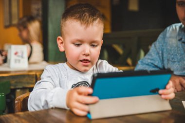 Tablet ile oturan küçük çocuk