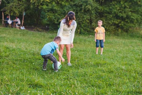 Madre giocare con figlio in palla a campo verde . — Foto Stock