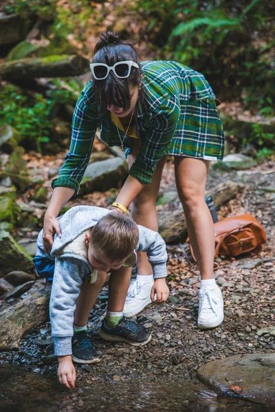 Mère avec enfant près de montagne rivière — Photo