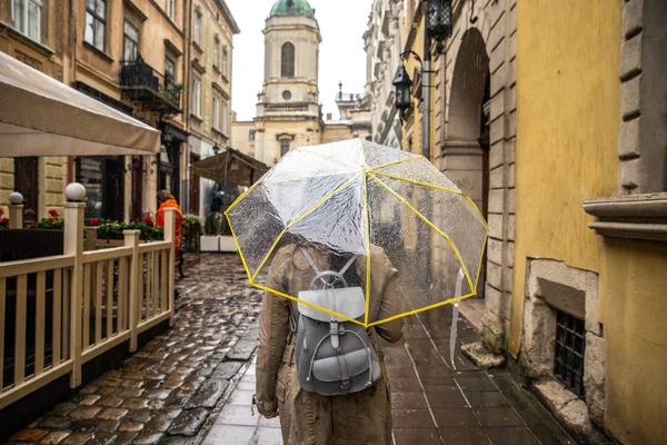 Donna che cammina con ombrello trasparente sotto la pioggia — Foto Stock