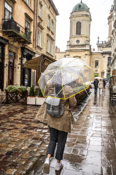 Mulher andando com guarda-chuva transparente sob chuva — Fotografia de Stock