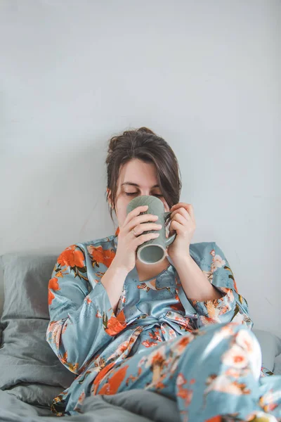 Young woman in pajama drinking tea in the morning — Stock Photo, Image