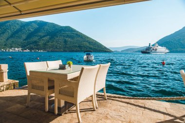 güzel bir deniz ve dağ manzarası ile sahilde Cafe tablo. üzerinde ayrılmış plaka