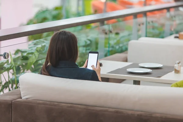 Kobieta z telefonem, siedząc w kawiarni — Zdjęcie stockowe