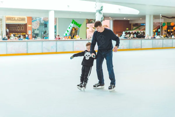 LVIV, UCRANIA - 3 de febrero de 2019: padre enseñando a su hijo a patinar en una pista de esquí — Foto de Stock