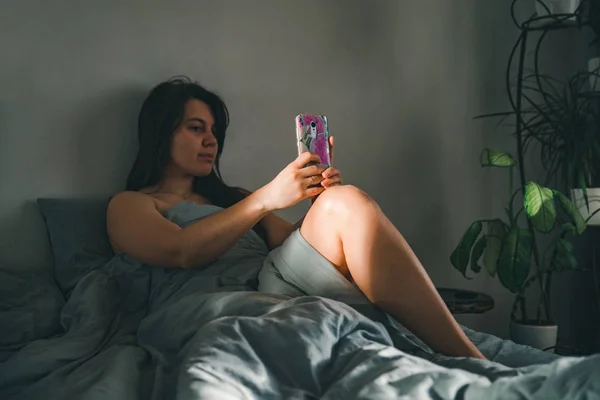 Nő reggel. az ágyban, a telefon. — Stock Fotó