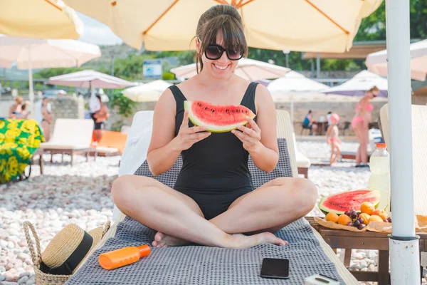 Mujer comiendo frutas en la playa. vacaciones de verano — Foto de Stock