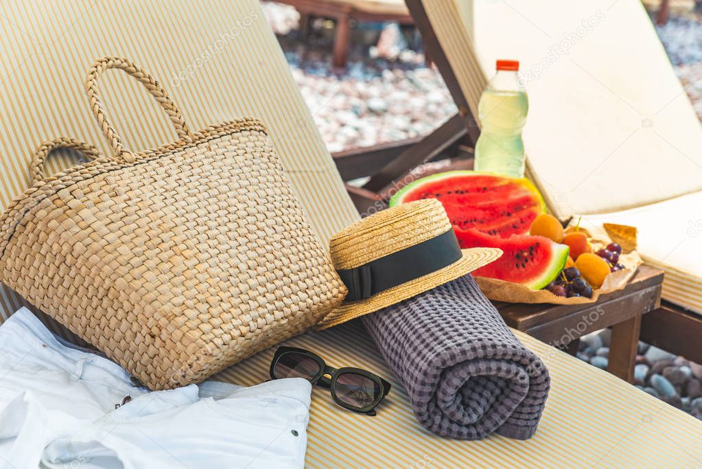 beach stuff bag towel blanket on sun longer. fruits on the table. summer vacation