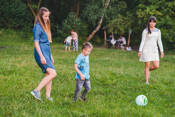 Madre jugar con hijo en pelota en el campo verde . — Foto de Stock