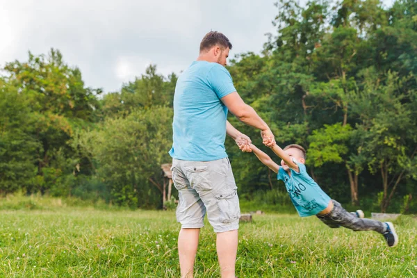 Homem a girar no campo verde. brincando — Fotografia de Stock