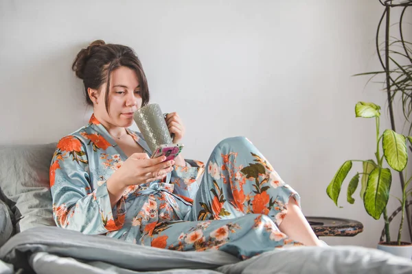 Frauenmorgen. im Bett mit Telefon. — Stockfoto