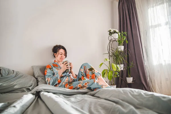 Young woman in pajama drinking tea in the morning — Stock Photo, Image