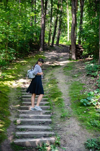 Жінка піднімається по старих сходах у лісі — стокове фото